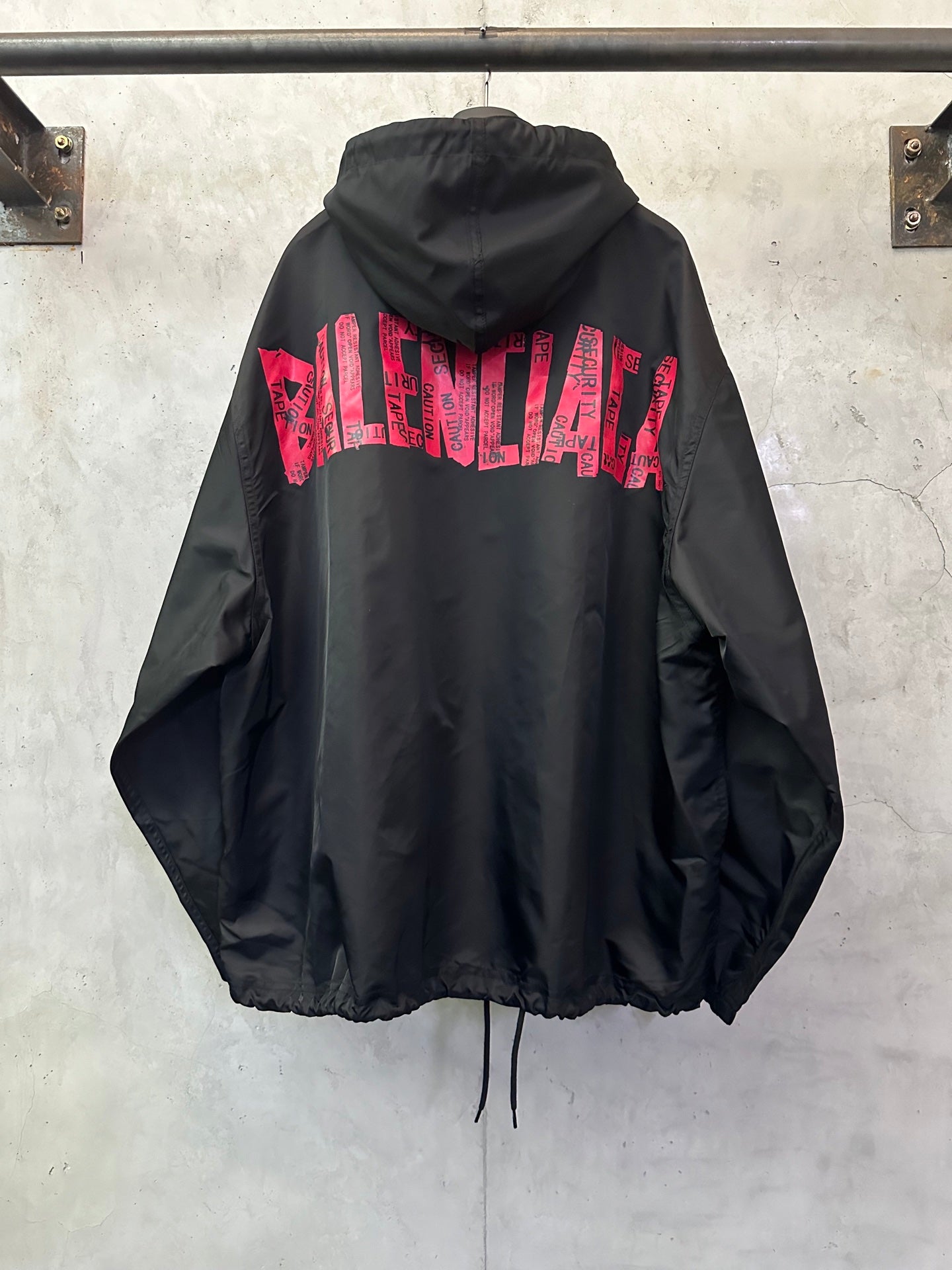 Black hooded jacket with red BALENCIAGA logo text across the back