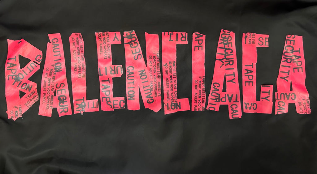 Close-up of black fabric with red and pink printed text logo pattern