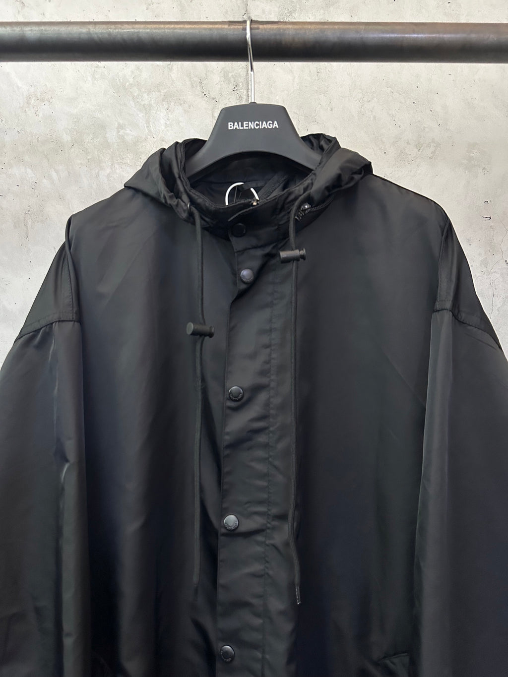 Black hooded jacket with front button placket and small chest pocket