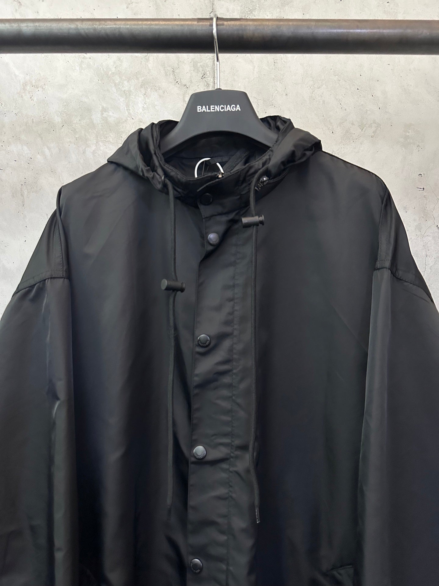 Black hooded jacket with front button placket and small chest pocket