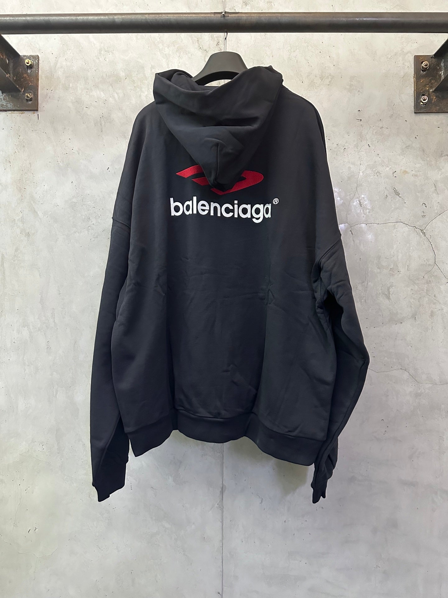 Black Balenciaga logo hoodie, back view with red emblem and cowl hood
