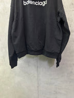 Black hoodie back view with ribbed cuffs and long sleeves, front hemline