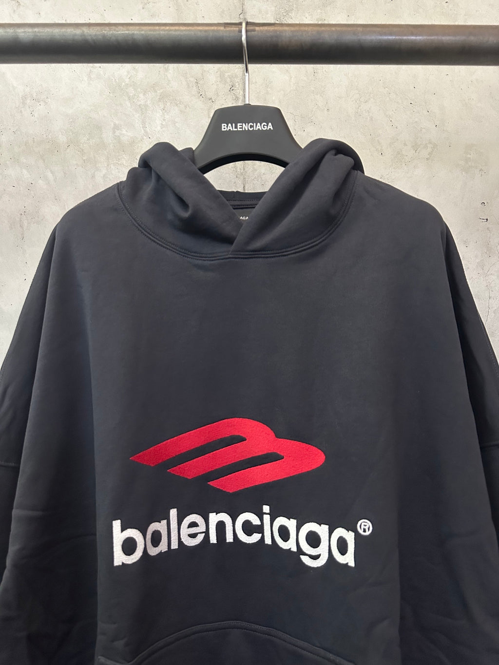 Black hoodie with red Balenciaga logo across chest, draped cowl hood
