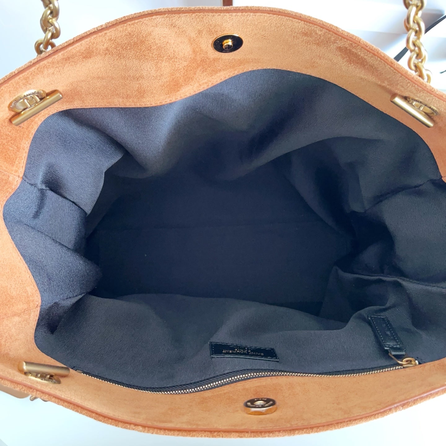 YSL tan tote interior with blue lining, inner pocket, and gold hardware buttons