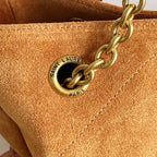 YSL oval logo plaque on tan suede with gold chain attachment