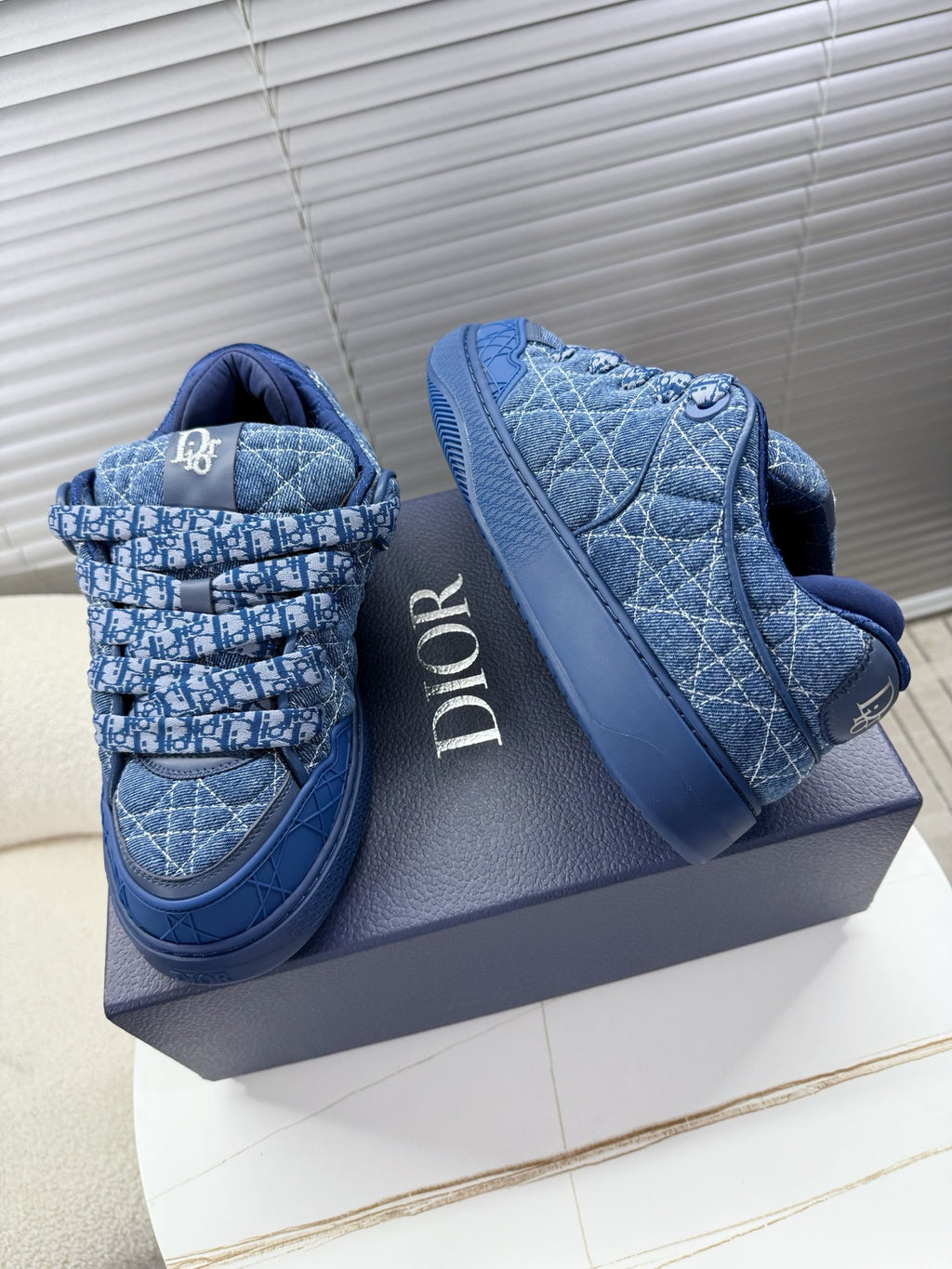 Blue unisex Dior sneakers, side view with quilted pattern and logo band
