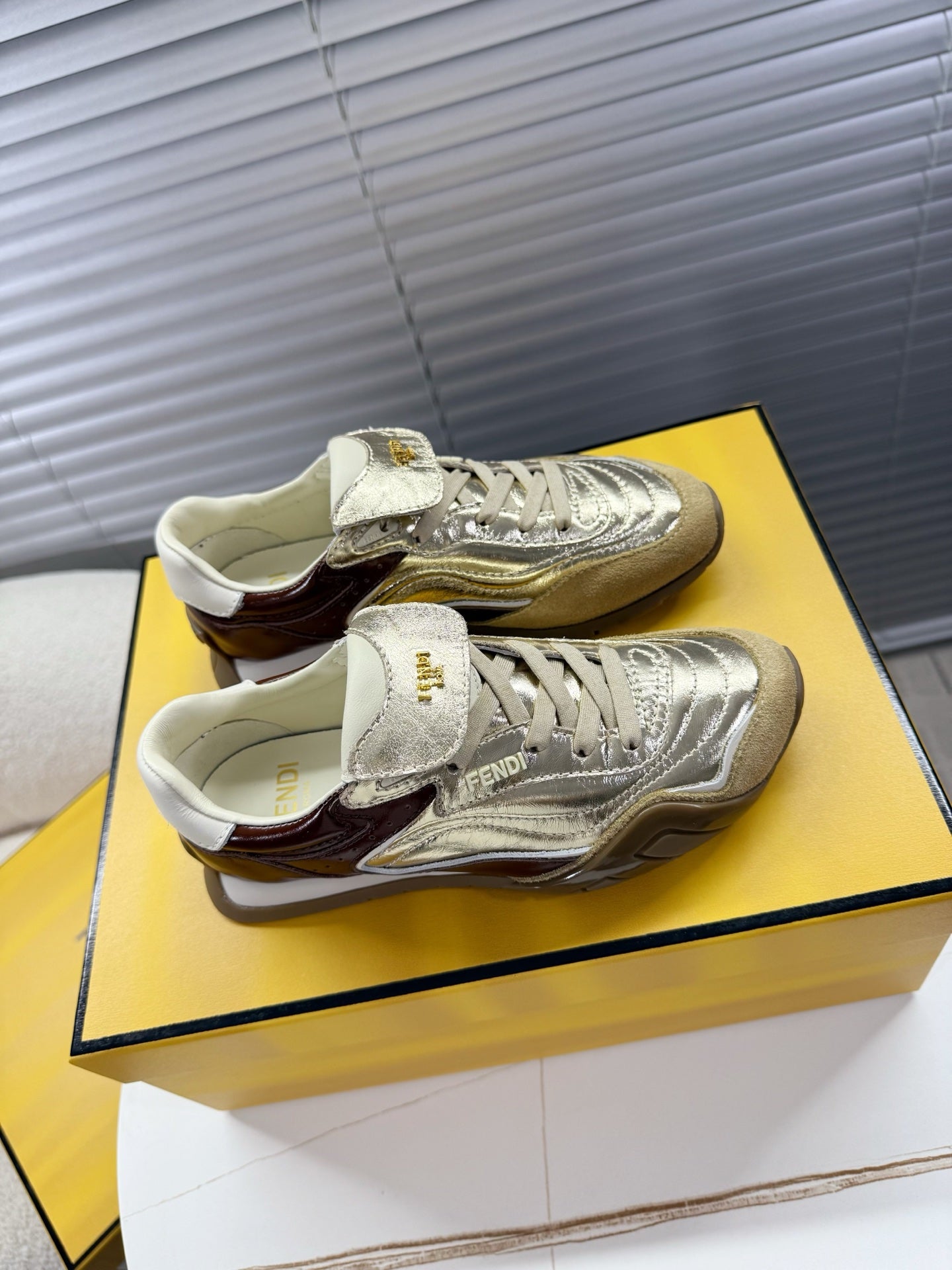 Fendi unisex luxury sneakers pair, metallic gold and silver lace-up style
