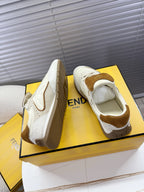 Pair of white low-top sneakers with brown suede heel accents and lace-up design