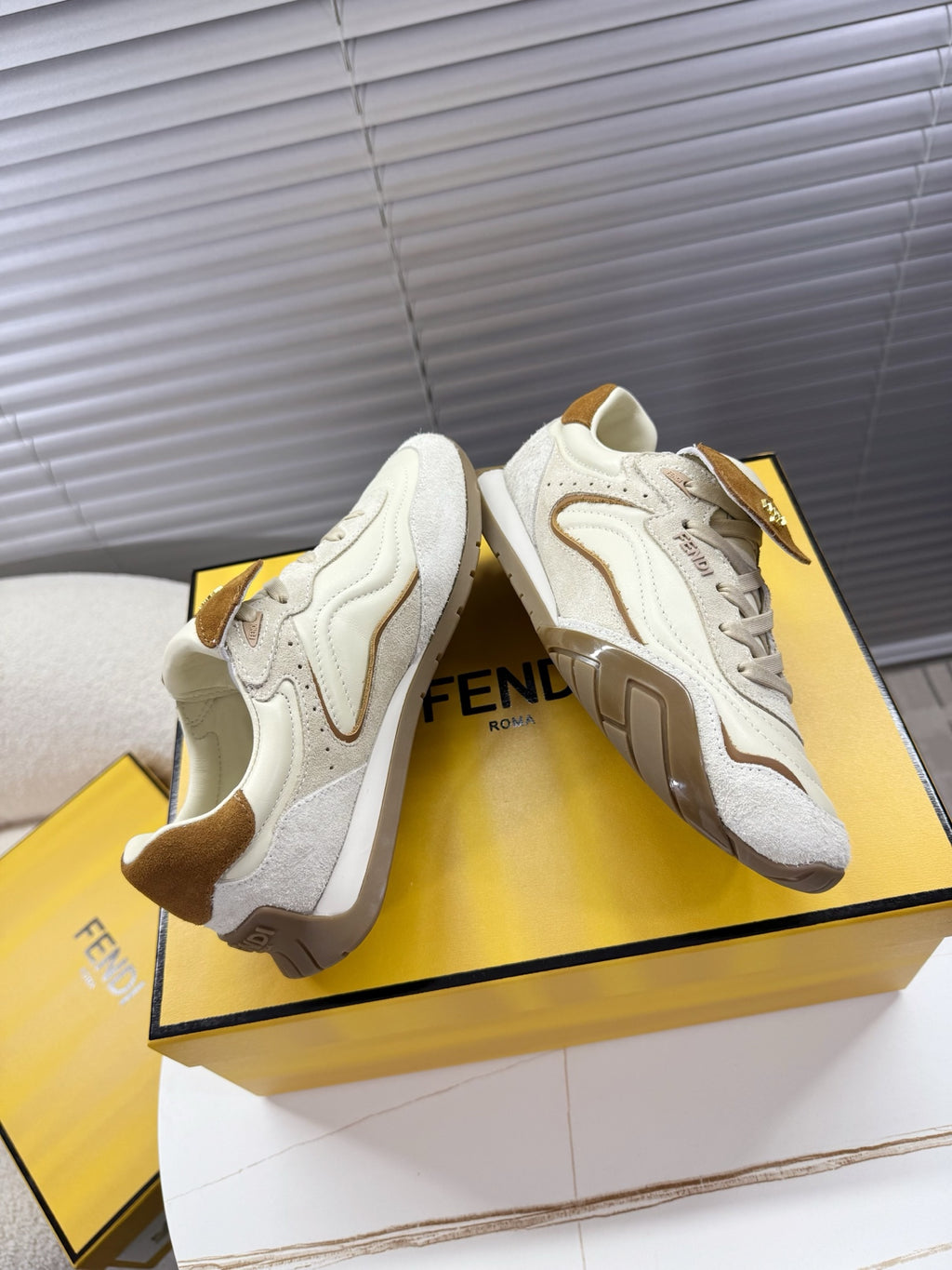 White leather sneakers with brown suede details and chunky rubber sole