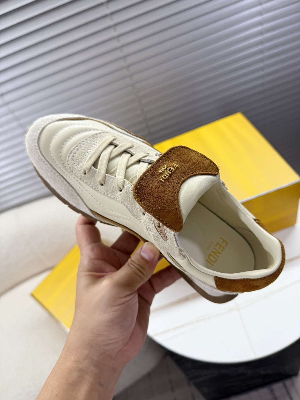 White leather sneaker with brown suede tongue tab and lace-up front