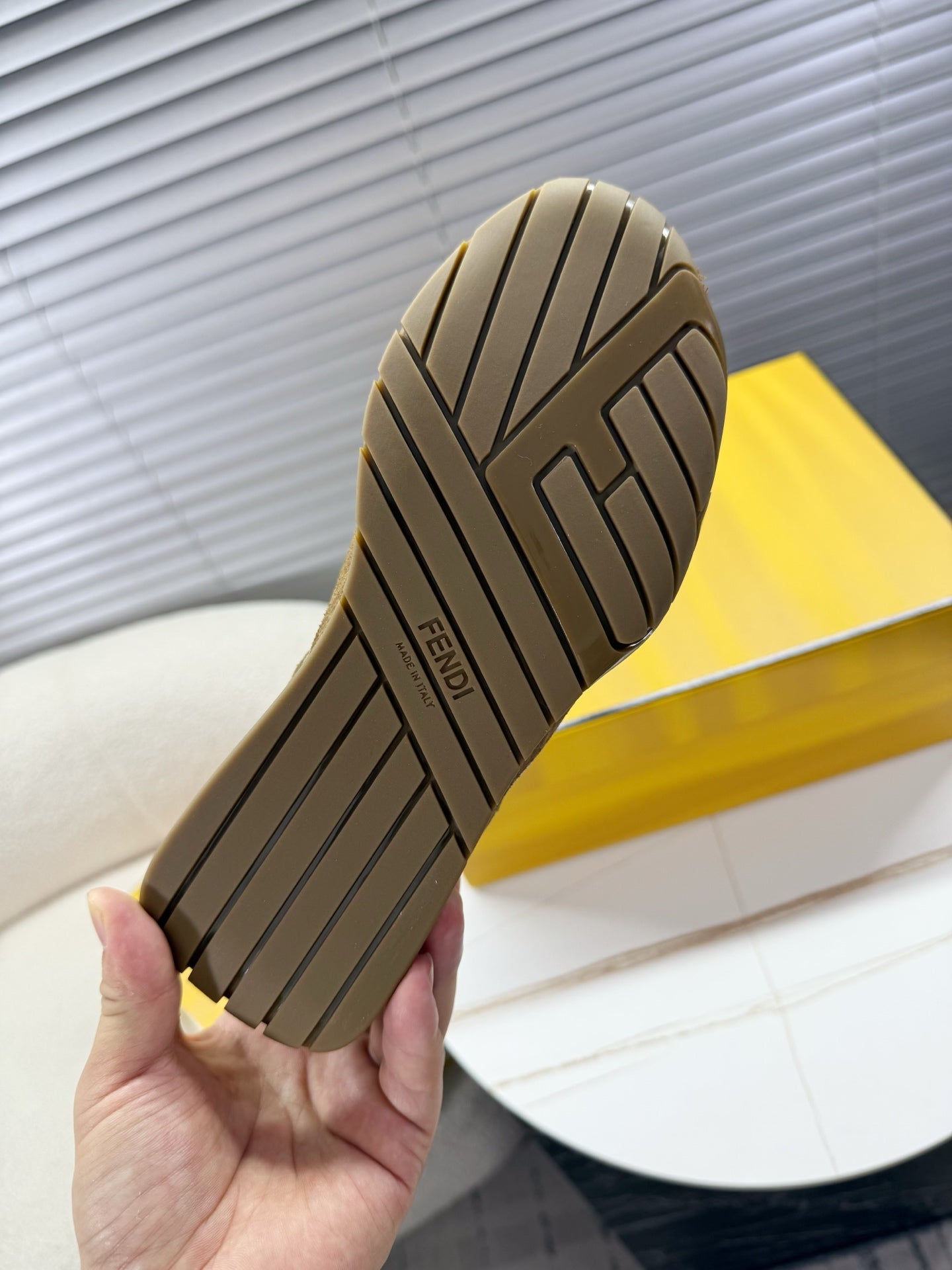Brown sneaker outsole with tread pattern and Fendi branding on heel
