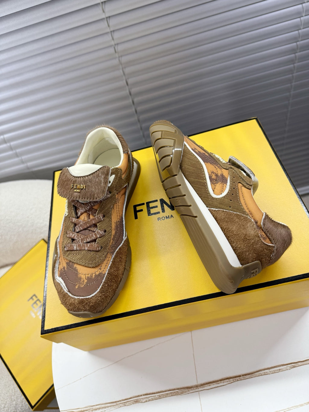 Brown lace-up low-top sneakers pair, showing side profile and white-trim detailing
