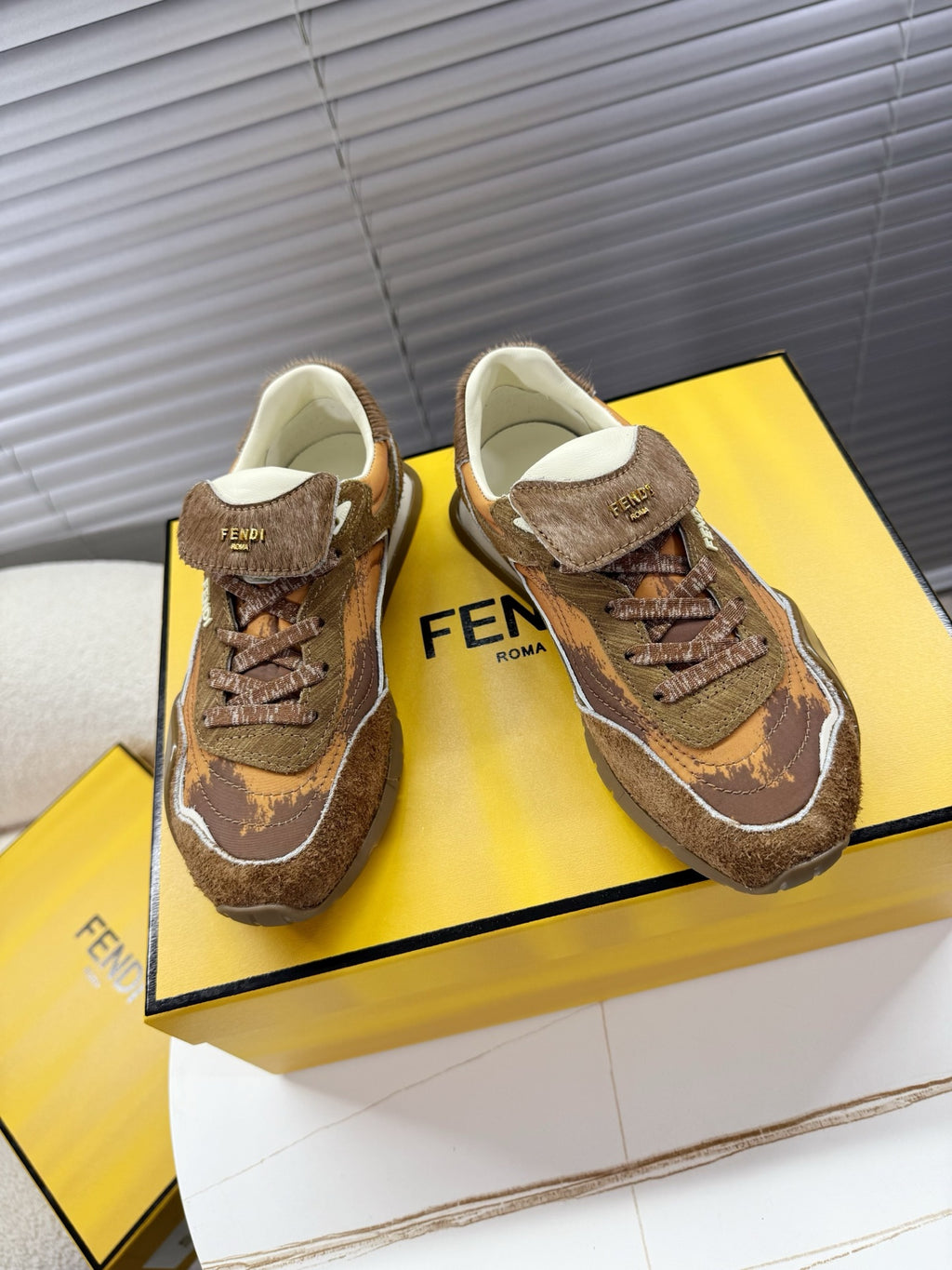 Brown lace-up low-top sneakers with white trim and Fendi Roma patch on tongue