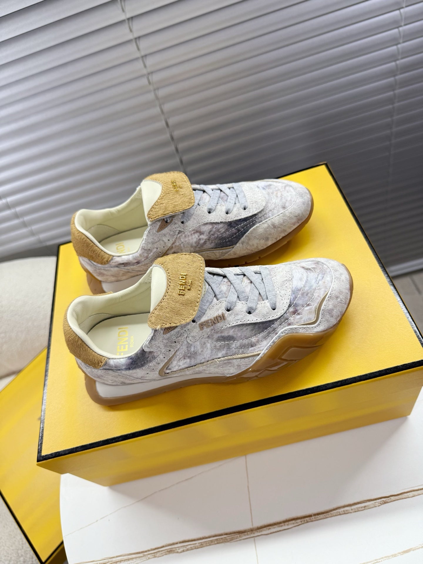 Light gray Fendi sneakers with tan suede straps and lace-up closure