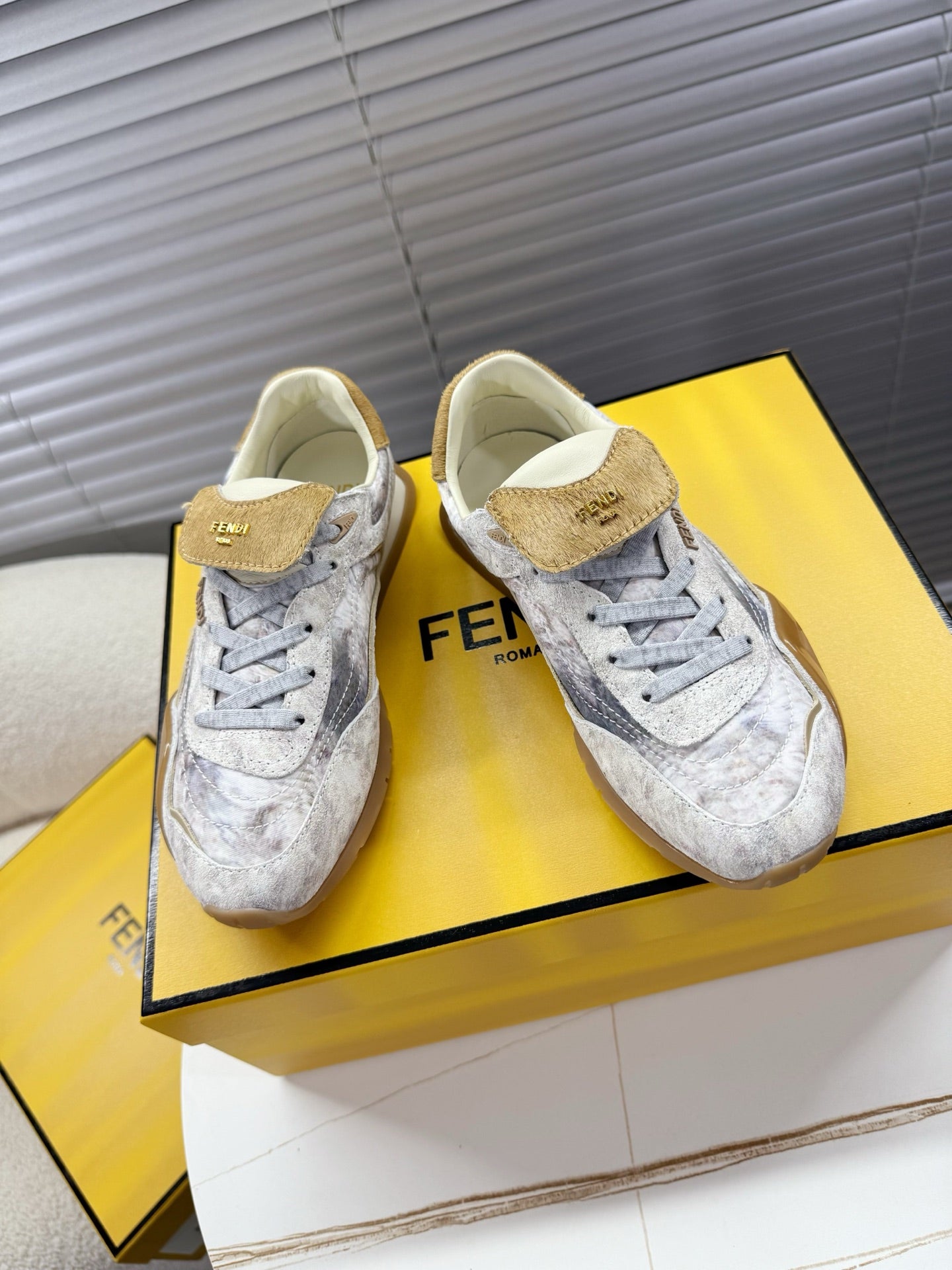 Light gray Fendi sneakers with tan suede accents and lace-up front