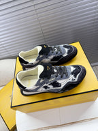 Fendi lace-up sneakers with black and white splatter, cream lining, top view of pair.