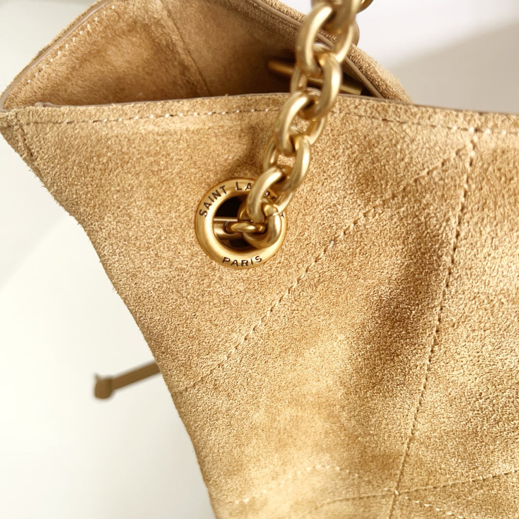 Gold chain and oval logo charm on tan suede tote bag