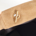 Tan suede pouch end detail with gold snap and circular logo emblem