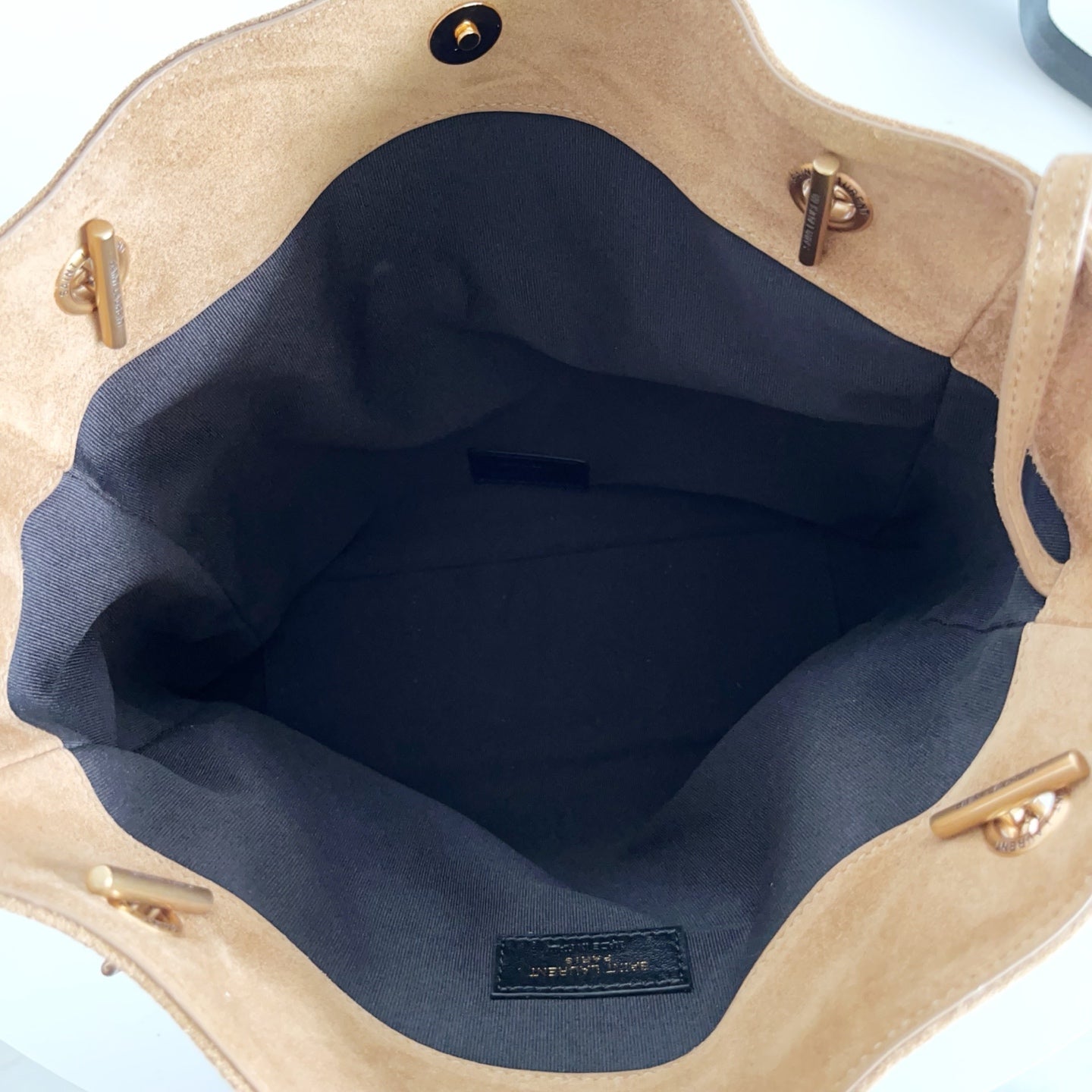 Tan suede tote bag interior with dark lining and zip pocket at back