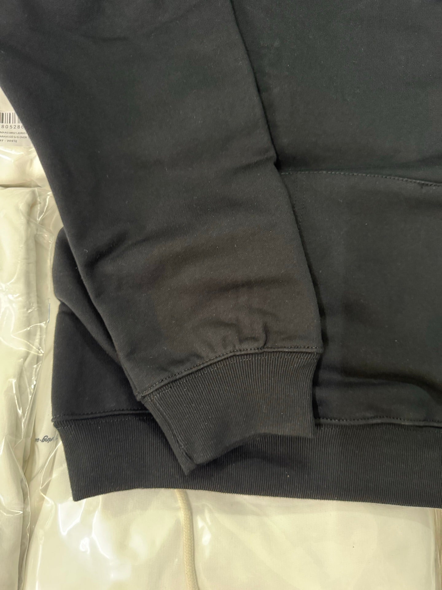 Black hoodie sleeve cuff with ribbed hem and side seam stitching