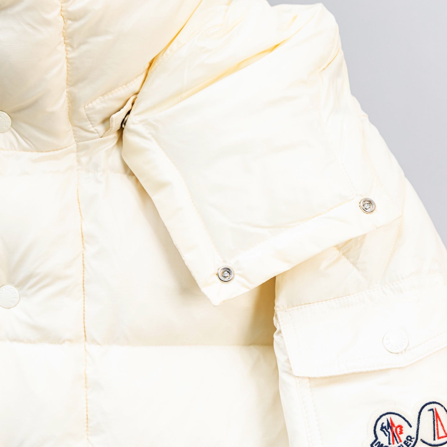 Moncler white puffer jacket sleeve detail with snap cuff and stitching