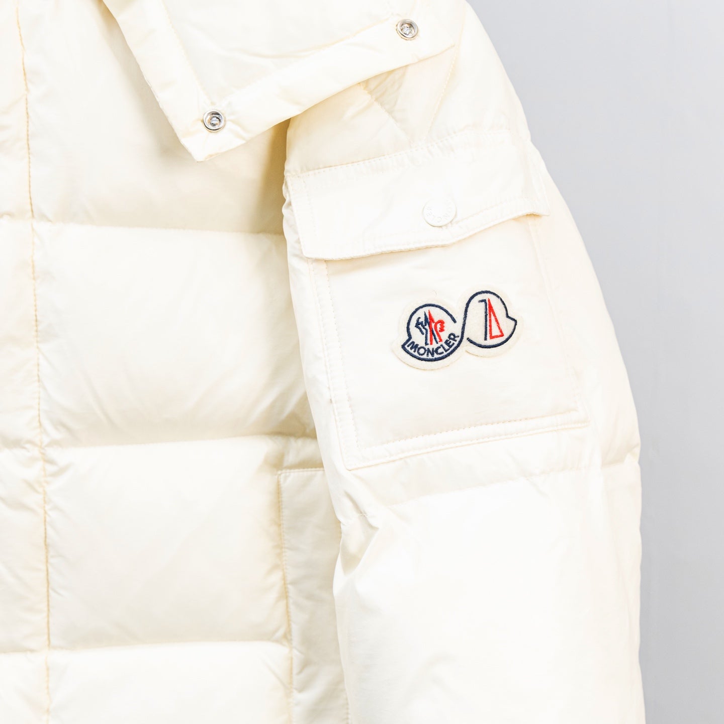 Moncler white puffer jacket with logo patches on the upper sleeve