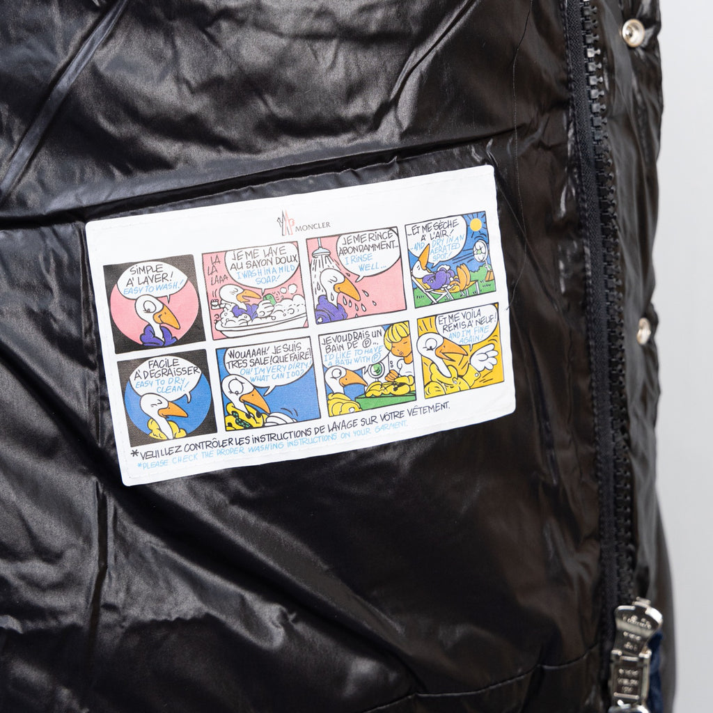 Moncler dark puffer jacket interior label area with printed instruction tag