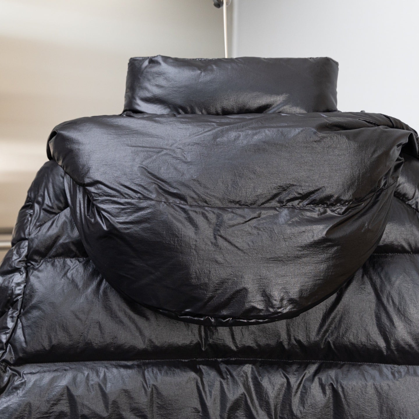 Moncler dark puffer jacket back view with high collar and quilted shoulders