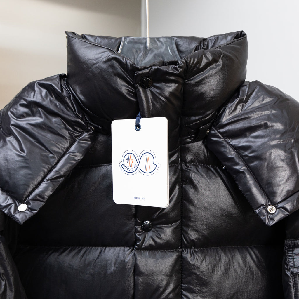 Moncler dark puffer jacket with hanging price tag and buttoned chest patch