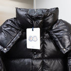 Moncler dark puffer jacket with hanging price tag and buttoned chest patch