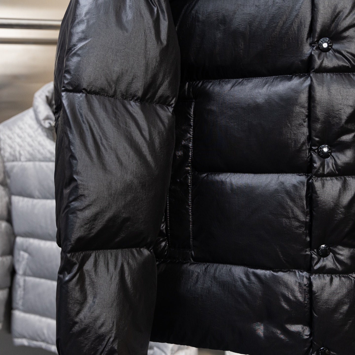 Moncler dark puffer jacket sleeve and torso close-up with quilted baffles