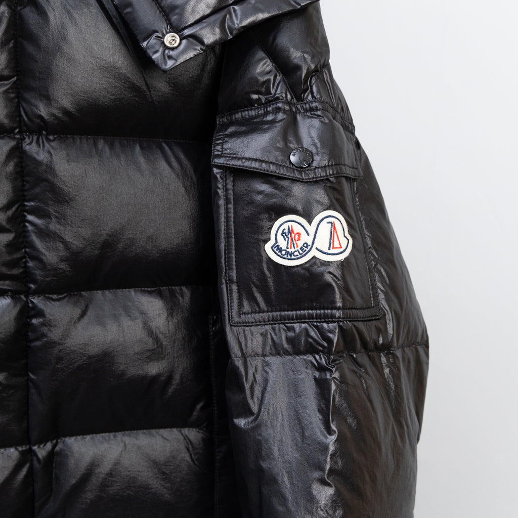 Moncler dark puffer jacket side view with chest pocket and button tabs