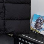 Black long puffer jacket front hem with zipper and textured trim