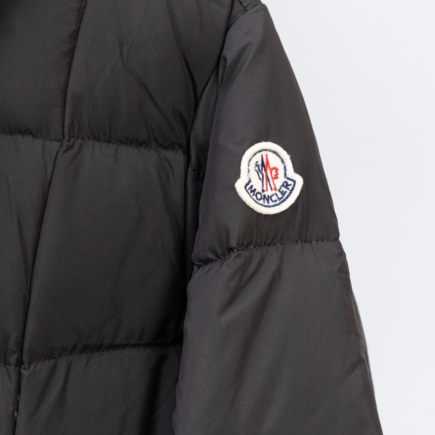 Black Moncler puffer sleeve with circular logo patch