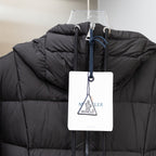 Black puffer coat with high collar and hanging logo tag on zip front