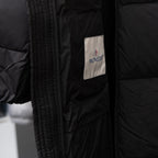 Black puffer jacket sleeve cuff with Moncler logo patch
