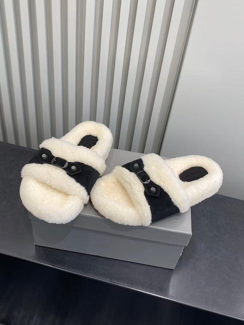 Balenciaga plush slide sandals on box, cream fuzzy straps with black buckle hardware