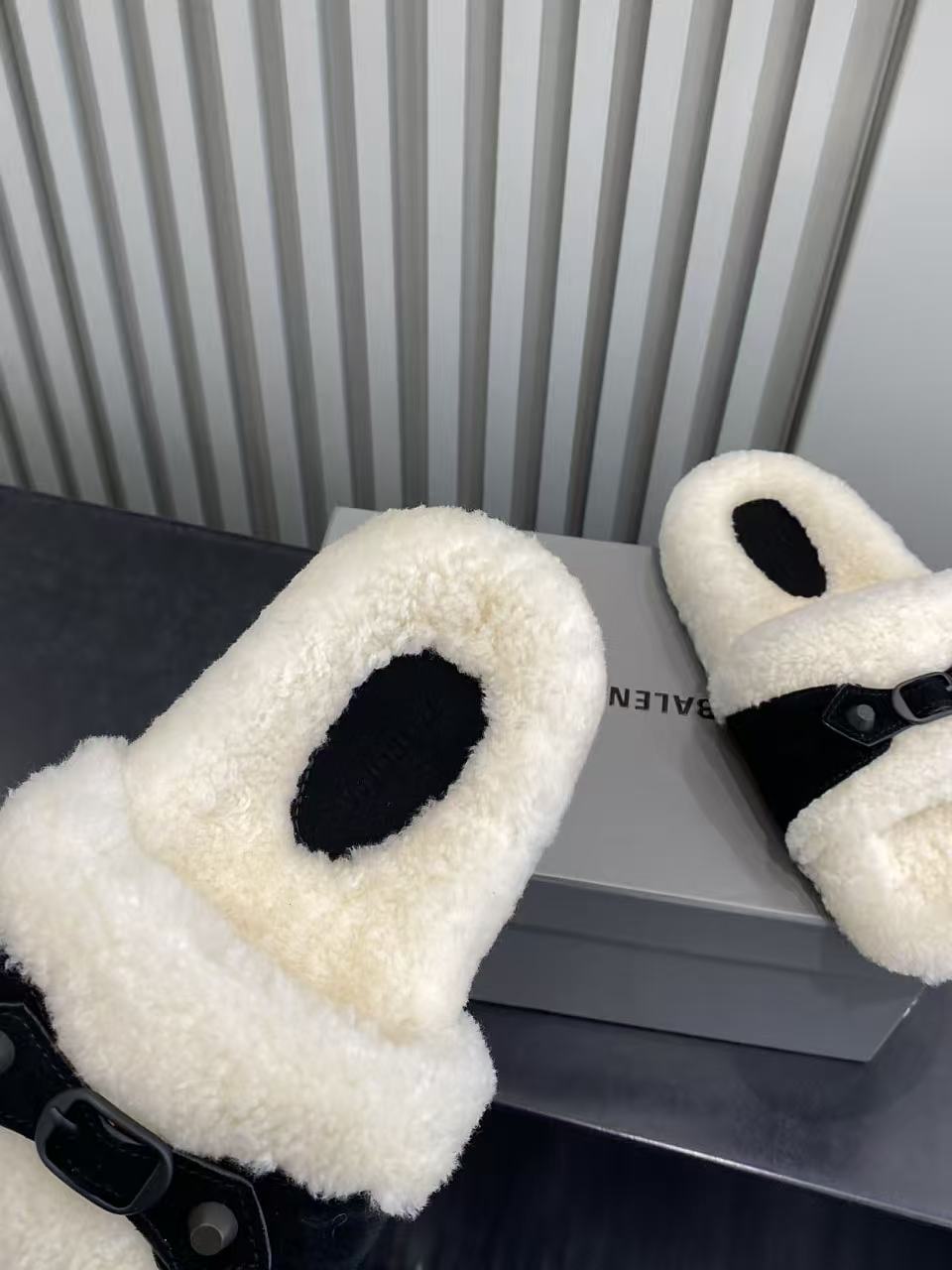 Balenciaga plush sandals close-up showing cream fuzzy upper and black adjustable strap