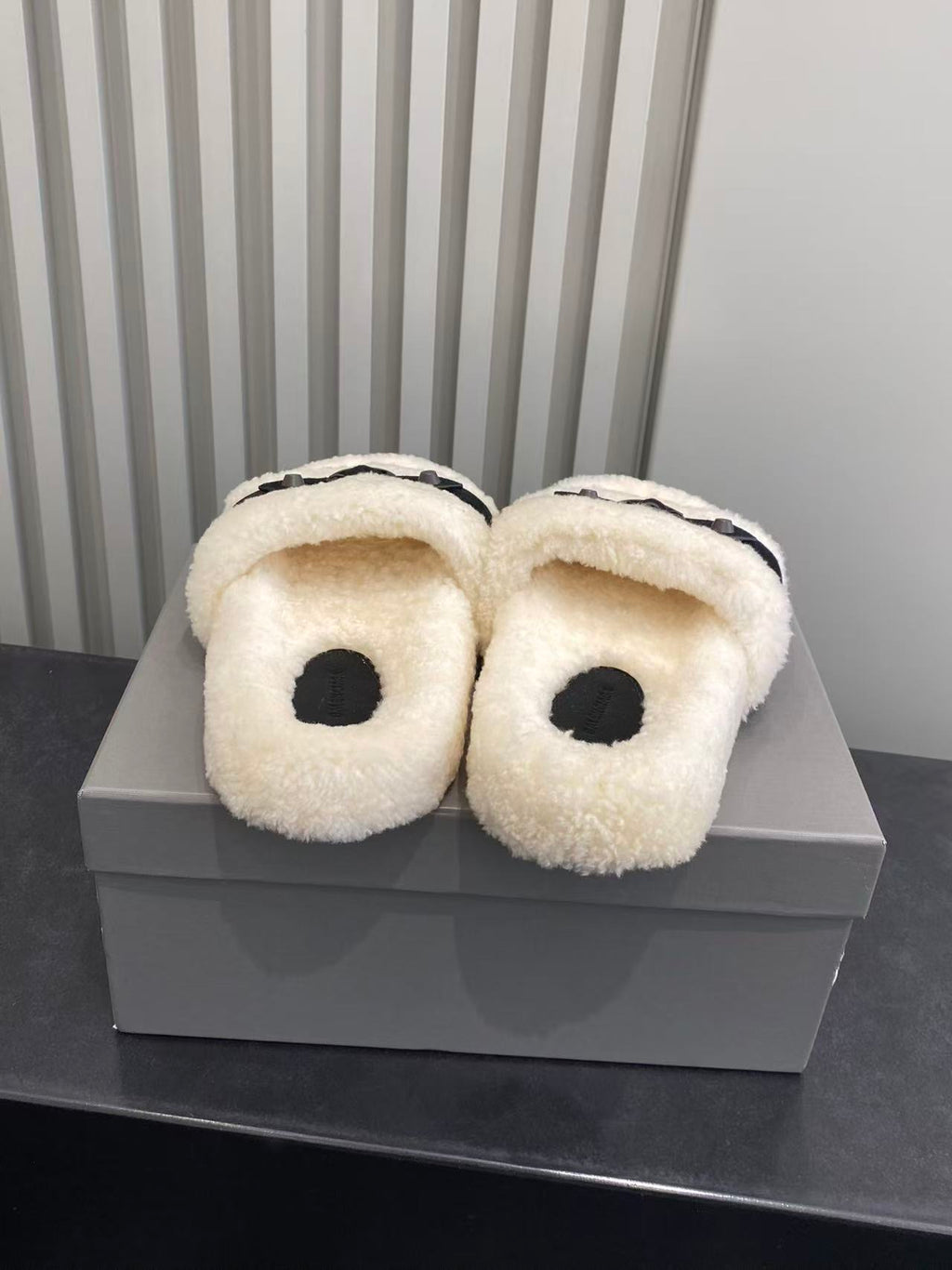 Balenciaga plush sandals viewed from top, cream fuzzy footbed and black strap