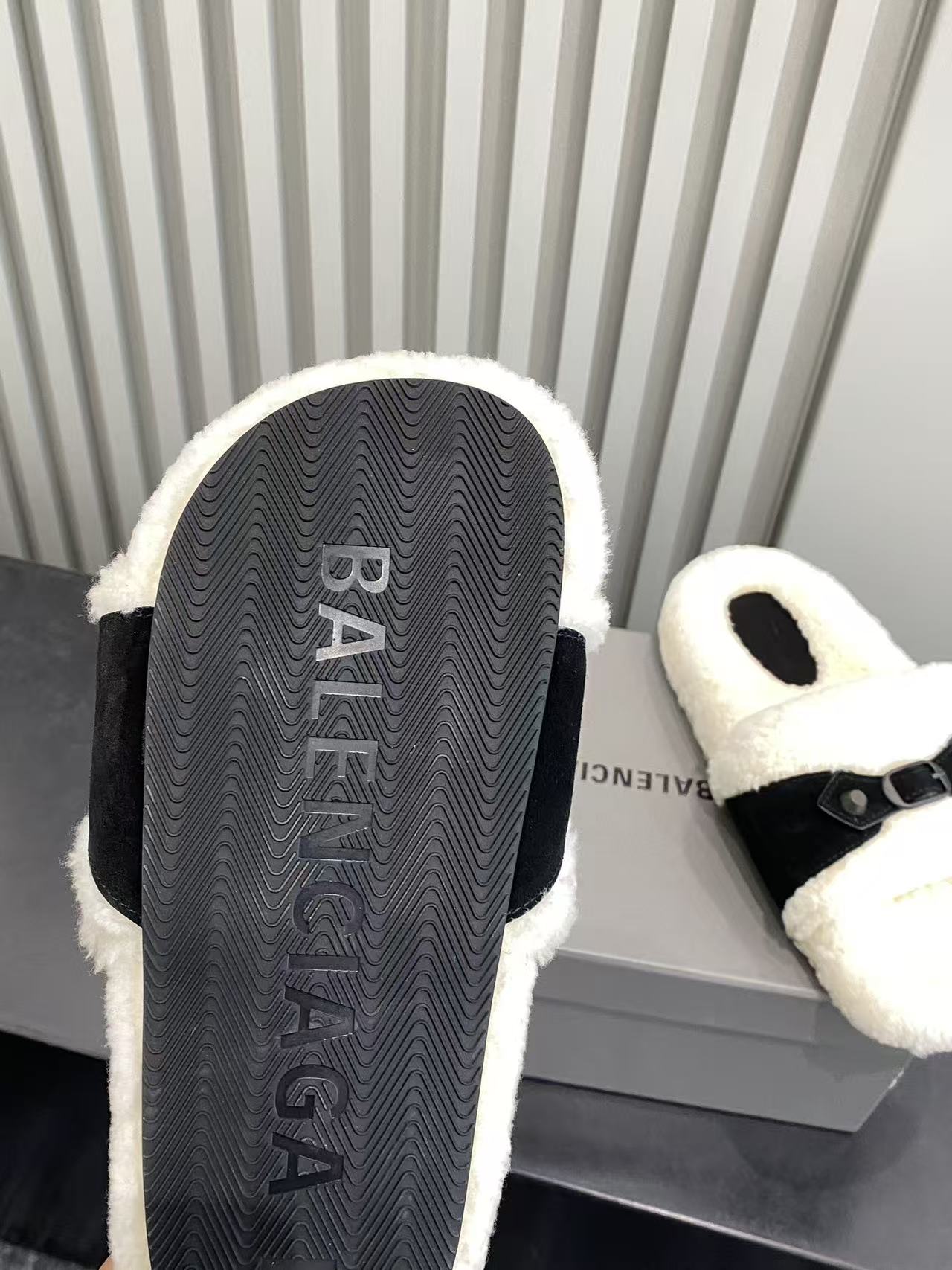 Balenciaga plush sandal sole view with textured black tread and cream fuzzy upper