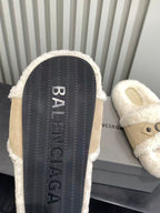 Treaded outsole of cream slide sandals with Balenciaga lettering on the sole