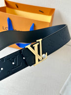 Dark monogram leather belt showing gold-tone LV buckle with small pearl detail.