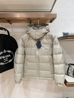 Long hooded puffer jacket in light beige, full-zip front with quilted baffles and logo patch