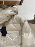 Long puffer jacket in light beige with quilted paneling, front snap placket and logo patch