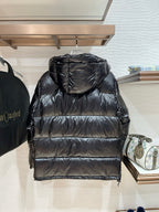 Black hooded puffer jacket with quilted stripes across the back