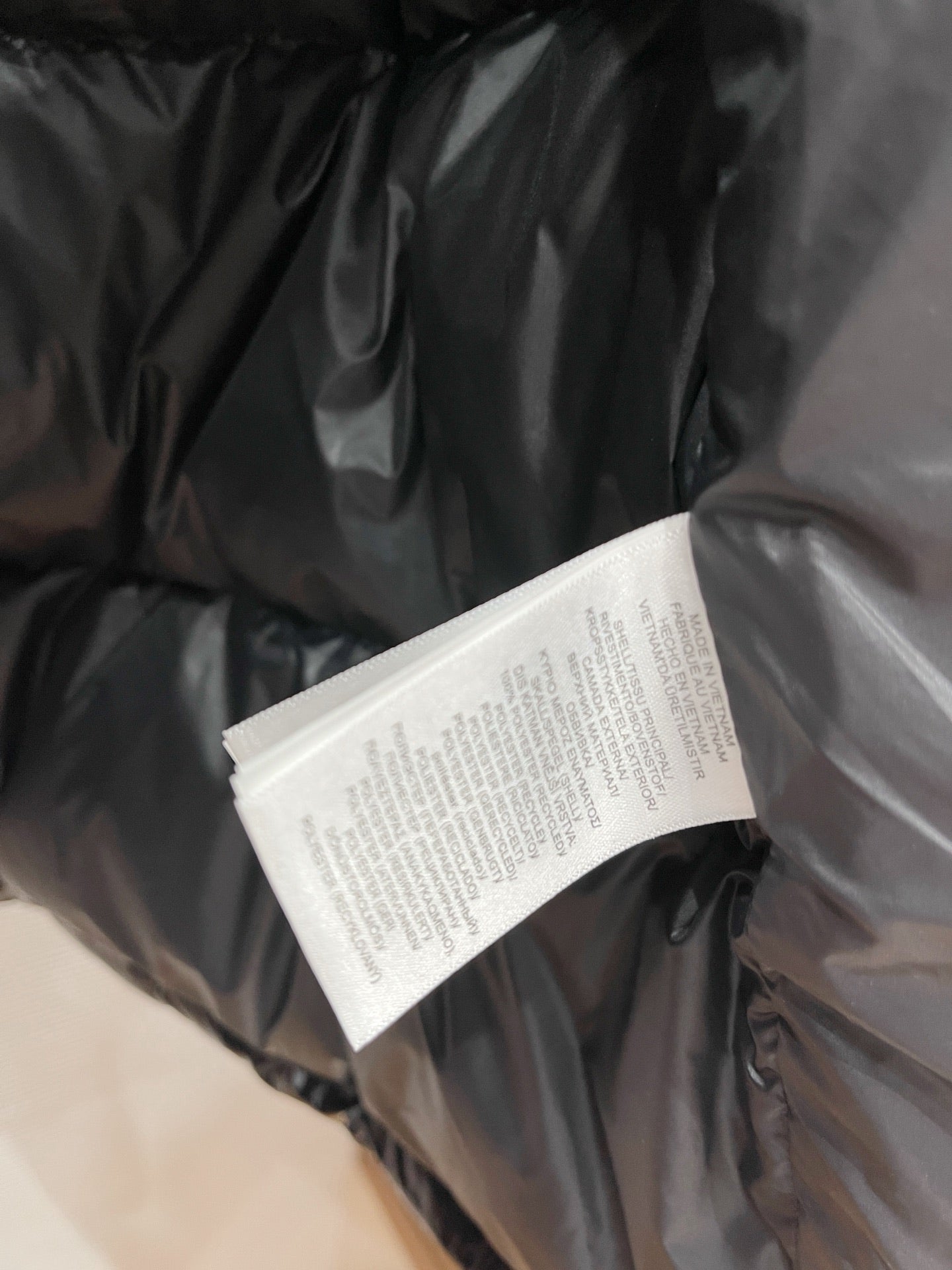 Black puffer jacket fabric with white care label tag