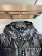 Black hooded puffer jacket with zip front and red polo logo at center