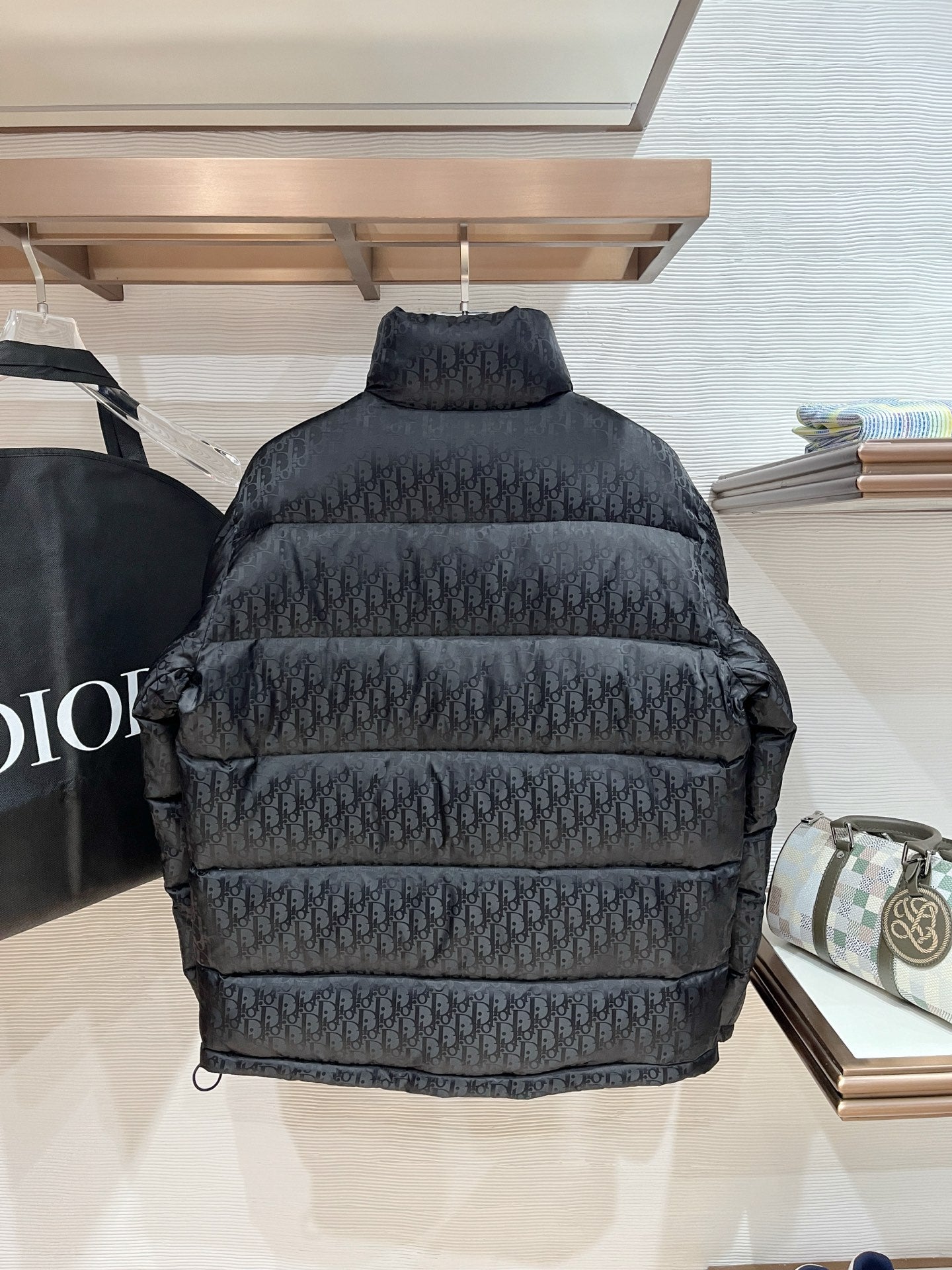 Black puffer jacket back view with quilted panels and high neck