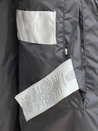 Black puffer jacket with white interior label and zip placket detail
