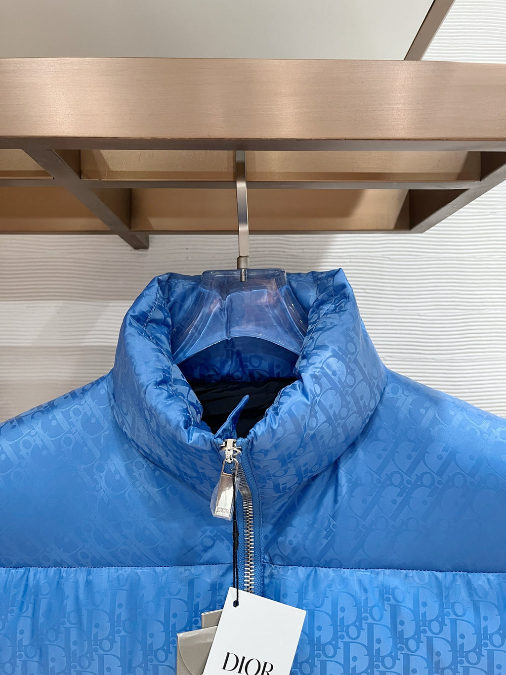 Blue quilted puffer vest with raised stand collar and front zipper close-up